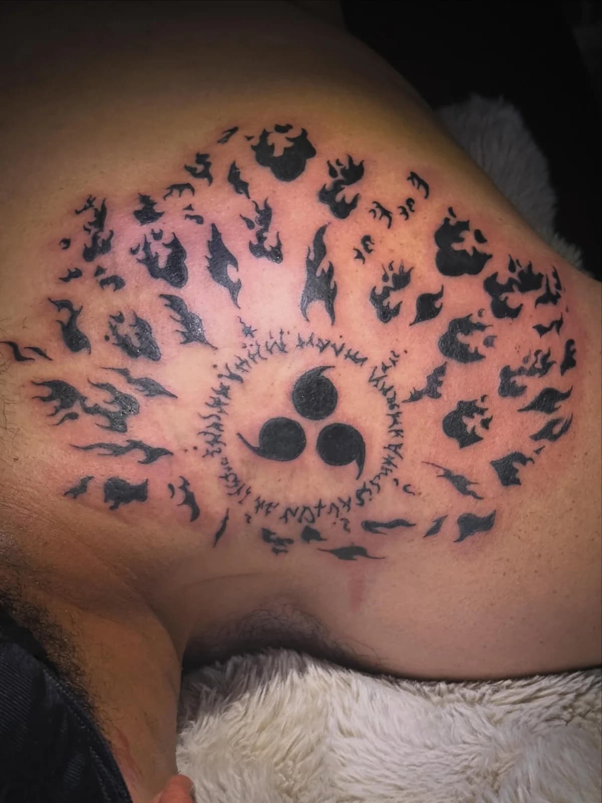 Large custom eye tattoo surrounded by silhouetted figures