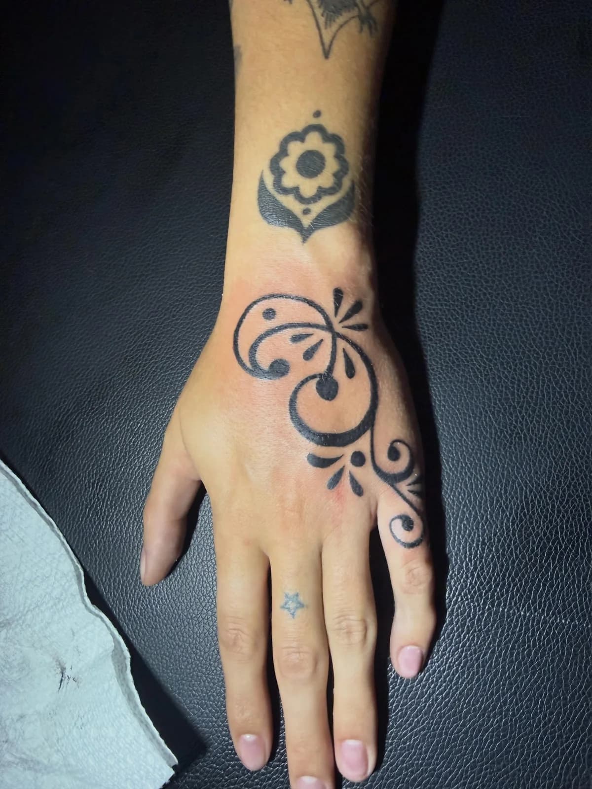 Ornamental hand tattoo with floral linework